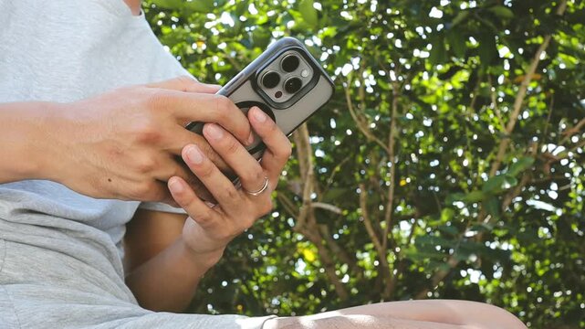 Close up video shot of a man typing on a smartphone outdoors for a digital banking transaction and online payment transfer