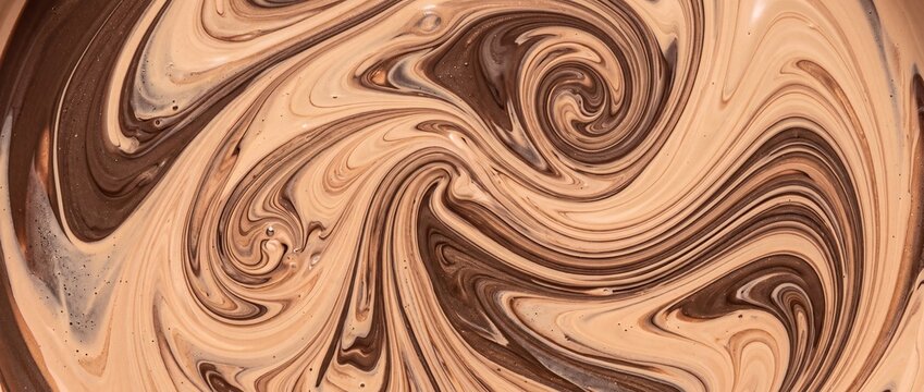 Swirling brown and beige liquid makeup foundation colors mixed together abstract pattern