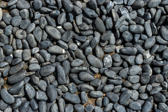 Background of smooth dark river stones and pebbles