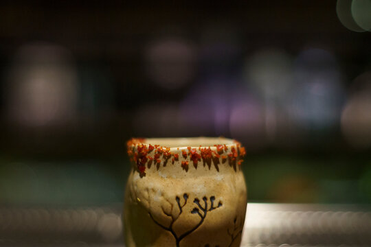 Close-up shot of a glass of a unique cocktail "Kaprao Moo Krob Kai Dao Mai Sook (crispy pork with chili  basil and fried egg)" which is based on Thailand's food of the same name inside bar in Bangkok