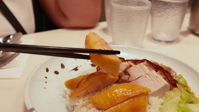 Chopsticks Picking Up Roast Chicken from a Hong Kong Style Rice Dish