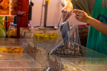 Obraz premium Vendor Bags Sunflower Seeds at Dihua Street Market