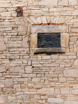 Old castle wall with window, built from irregular stones