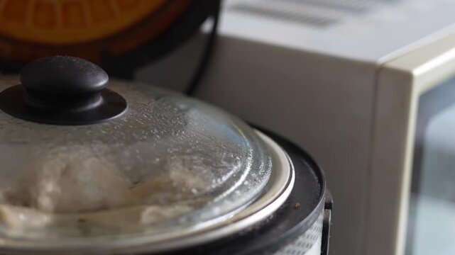 Glass lid on pot cooking hot food covered with condensation.