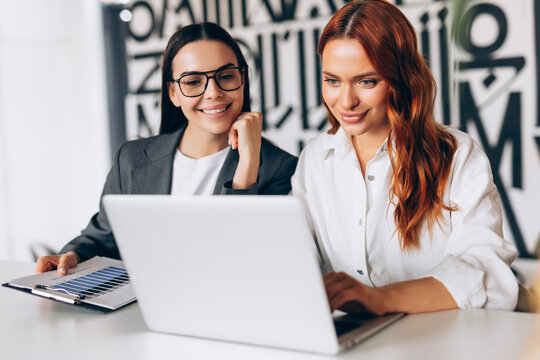 Businesswomen collaborating on laptop analyzing financial data