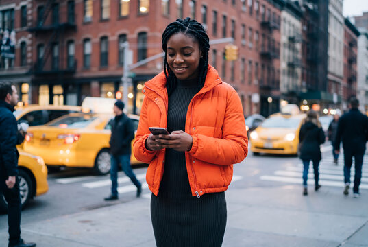 African American young woman texting on urban city street