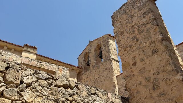 Medieval stone church bell tower against a clear blue sky