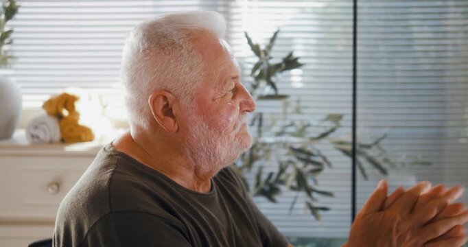 Side profile of a senior man applying face cream in the bathroom during his morning skincare routine, gently massaging moisturizer into his skin.