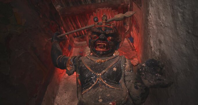 Annapurna Circuit, Manang, Nepal, zoom-out shot revealing the talll ancient clay and pigment Vajrapani protector statue in Bhraka Monastery
