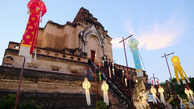 Colorful Lanna lanterns decorate historic Wat Chedi Luang temple for the Yi Peng Festival in Chiang Mai, Thailand, with the ancient Buddhist chedi at dusk