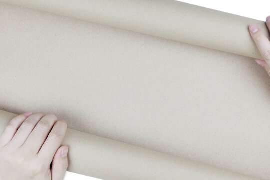 Hands unrolling brown kraft paper scroll with blank copy space. Concept of announcement, unveiling story, eco-friendly paper, and blueprint.