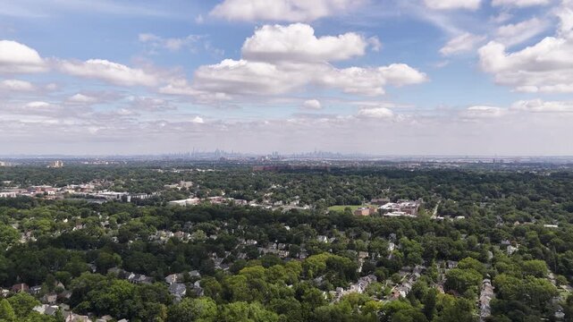 A smooth drone pan crosses Maplewood and South Orange neighborhoods while following the distant metropolitan horizon toward the Manhattan skyline.