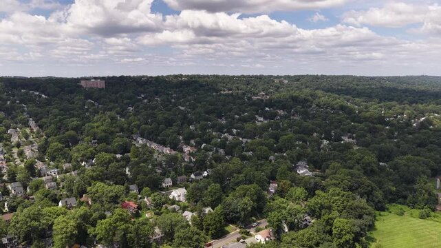 The drone transitions from an oblique wooded horizon to a vertical top down view of homes, streets and backyards near Maplewood and South Orange, New Jersey.