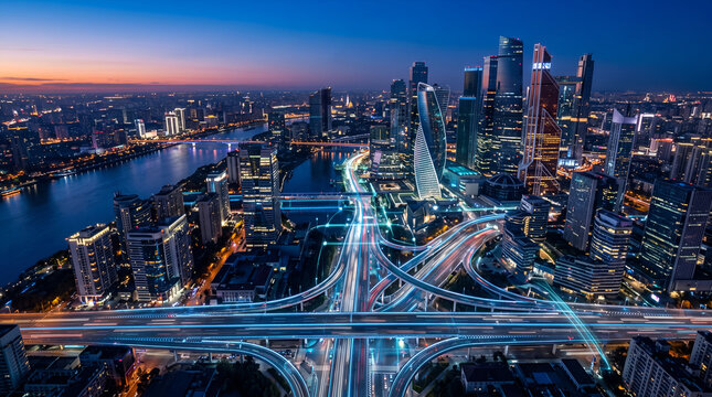 Aerial View of Modern City Skyline and Highway Interchange with Light Trails at Night
