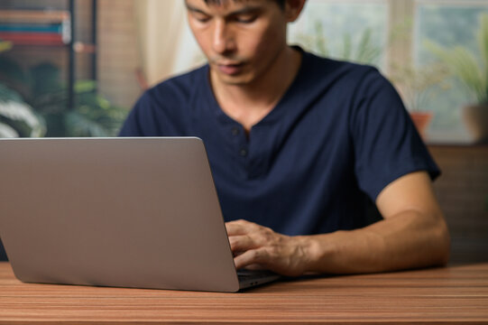 Young Man Working on Laptop in Modern Workspace with Natural Light