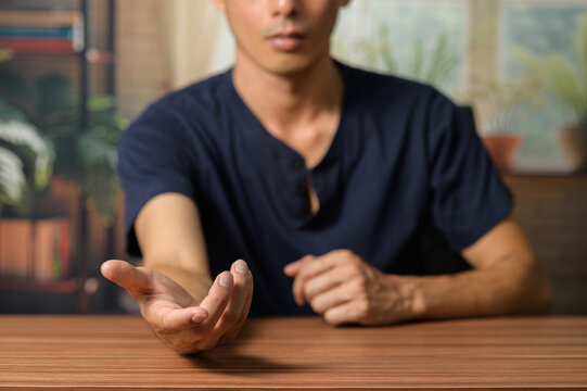 Male Individual Extending Hand in Casual Indoor Setting for Greeting
