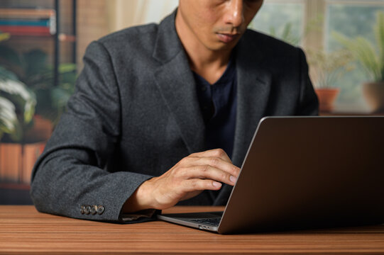 Professional Man Working on Laptop in Modern Home Office Setting