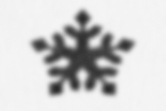 Minimalist black snowflake icon on white background. Blurred winter crystal symbol. Abstract frozen ice star element for seasonal design.
