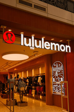 Warsaw, Poland, 20 August 2026. Lululemon retail store entrance with illuminated logo, activewear on mannequins, and Warsaw themed neon sign