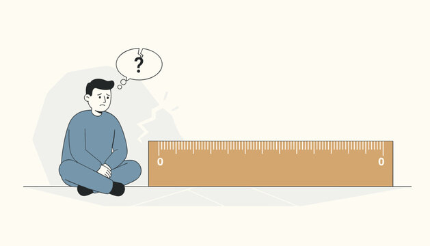 Confused man sitting on the floor thinking next to a large brown wooden ruler with zero marked on both ends.