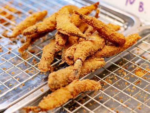 Crispy Deep Fried Battered Fish Strips Cooling on Wire Rack at Thai Street Food Market Stall