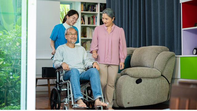 Asian old man on wheelchair with couple and nurse relaxing walking at home, healthcare medical service at nursing home