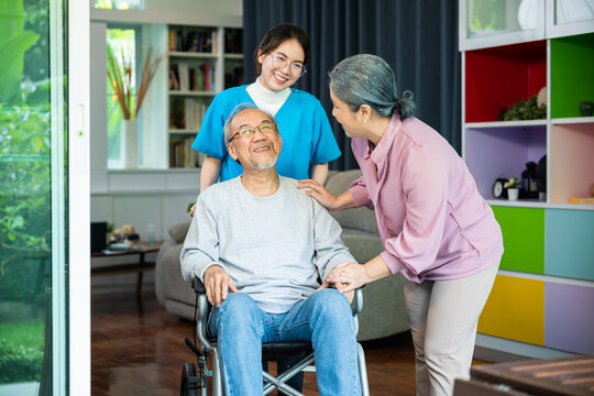 Asian old man on wheelchair with couple and nurse relaxing walking at home, healthcare medical service at nursing home