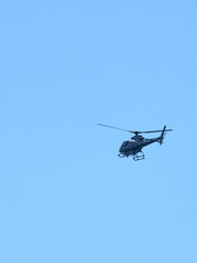 Fototapeta premium Modern Utility Helicopter Flying in Clear Blue Sky