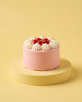 Tactile Macro Detail: Pastel Pink Bento Cake with Buttercream Piping on Yellow Stage