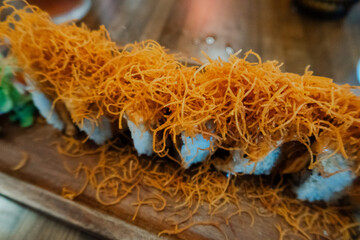Gourmet sushi roll topped with crispy fried noodles © Cavan