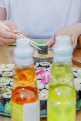 A person dipping a maki sushi roll into sauce © Cavan