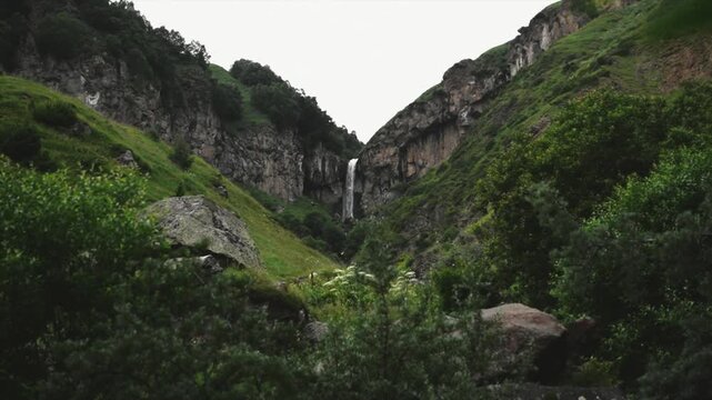 Majestic waterfall cascades into a lush green valley
