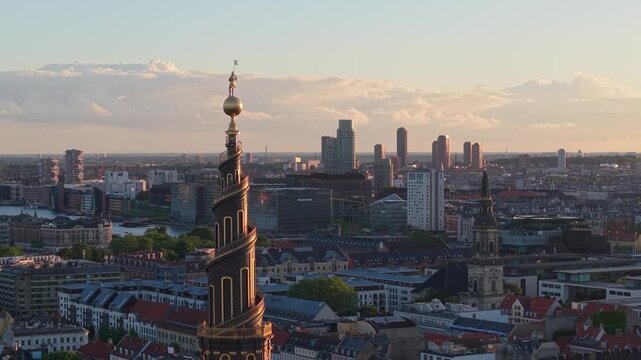 Drone footage ascending behind Our Saviour's Church Belfry (Vor Frelsers Kirke), gradually revealing Copenhagen's cityscape, historic architecture, and urban skyline from above.