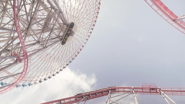 The Cosmo Clock 21 Ferris Wheel And Vanish Diving Roller Coaster At Yokohama Cosmo World In The Minato Mirai 21 District Of Yokohama, Kanagawa, Japan. Low-angle Shot