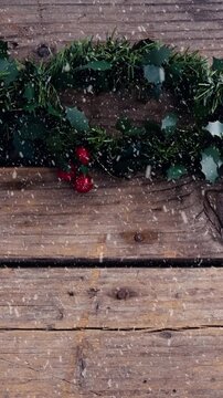 Animation of christmas decoration with snow falling on wooden boards