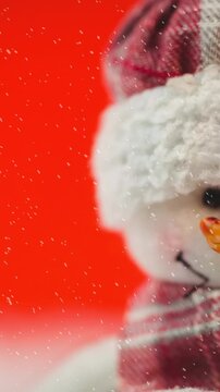Animation of snow falling against christmas snowman on red