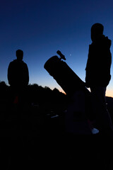 Amateur astronomers observing stars, planets, Moon and other celestial objects with a telescope in nature. © astrosystem