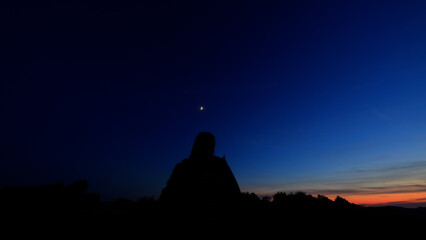 Silhouette of a person in nature observing night sky, Moon, stars and planets from a remote location. © astrosystem
