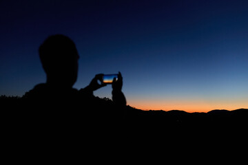 Amateur astronomer with smartphone photographing and observing stars, planets, Moon and other celestial objects. © astrosystem