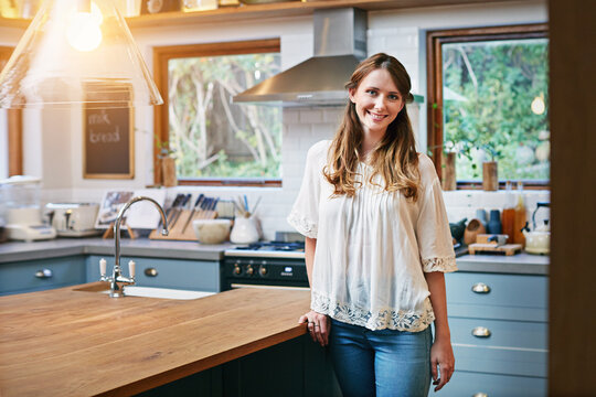 Happy, portrait and woman in kitchen with smile for pride, confidence and relax on weekend. Morning, home and person by counter with positive attitude, good mood and me time for break or holiday