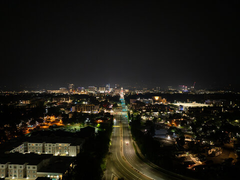 Night aerial view of cityscape with roads, buildings, and distant lights