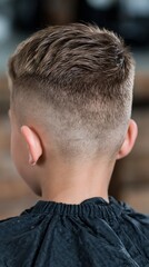 Fototapeta premium Young boy getting a fresh and stylish haircut with a clean fade