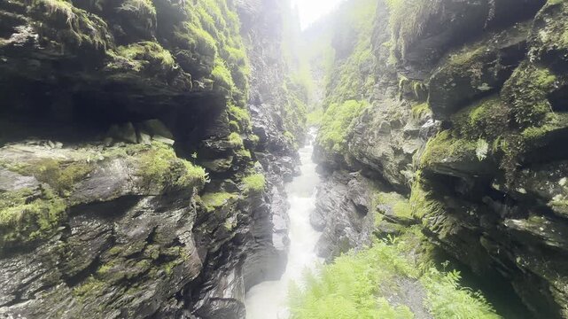 Steady locked off shot of the deep stone chasm and rushing glacial water at Bordalsgjelet Gorge