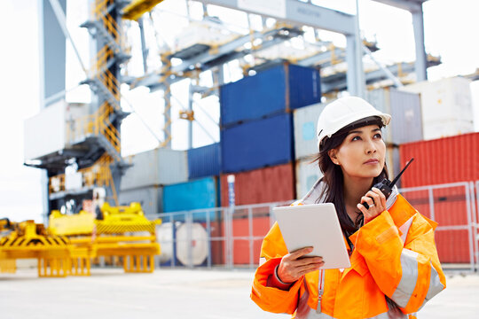 Woman, tablet and supply chain by shipping container with radio, thinking or idea for coordination. Outdoor, mature person or supervisor with tech for logistics, problem solving or freight operations