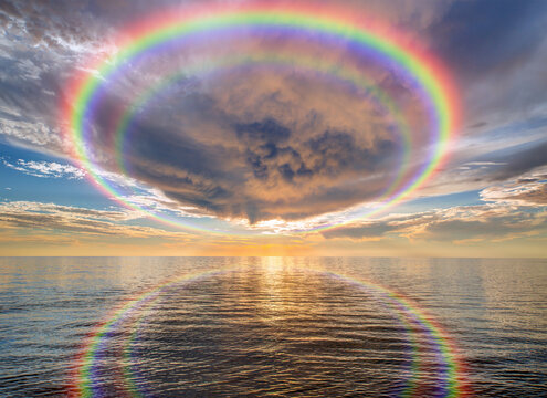Calm sea before storm with amazing rainbow at sunset   