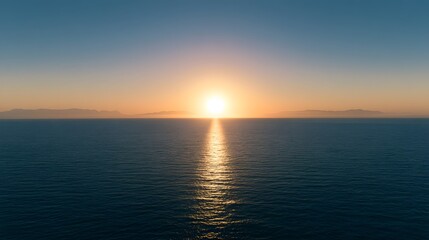 Fototapeta premium Cinematic wide shot of a tranquil ocean at sunset with golden sun rays reflecting on calm water surface