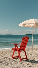 Obraz premium Vibrant red Adirondack chair and umbrella on a serene sandy beach, overlooking calm ocean waters under a clear blue sky.