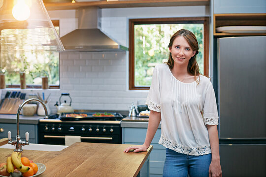Happy, portrait and woman in kitchen on weekend for pride, confidence and relax for vacation. Morning, home and person by counter with positive attitude, good mood and me time for break or holiday