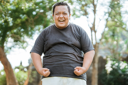 fat man wearing sportswear styled like a bodybuilder in an outdoor background