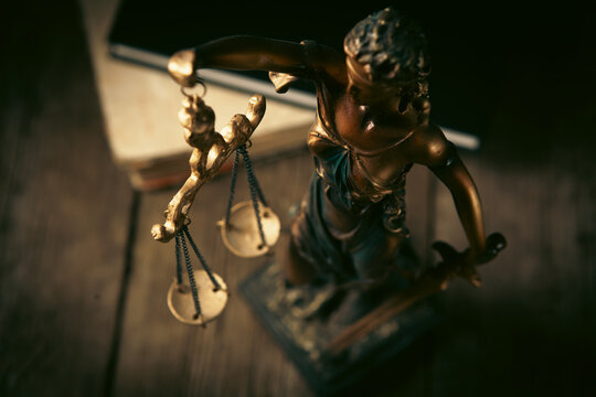 Statue of justice and books on wooden table. Law concept.